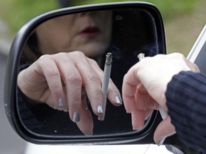 In this Saturday, March 2, 2013 photo, a woman smokes a cigarette while sitting in her truck in Hayneville, Ala. A new study released on Monday, March 4, 2013 offers more compelling evidence that life expectancy for some U.S. women is actually falling. A new study found that over 10 years, death rates for women under age 75 increased in nearly half of U.S. counties - many of them rural and in the South and West. There was no such trend among men. Some leading theories blame higher smoking rates and higher unemployment, but several experts said they simply don't know.