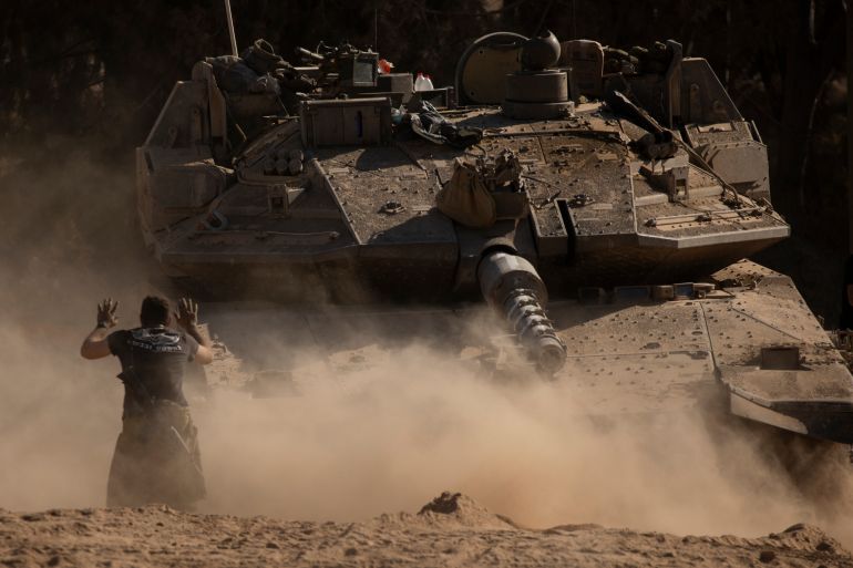 ISRAEL - JULY 08: An Israeli soldier directs a tank near the border with the Gaza Strip on July 8, 2024 in Southern Israel. More than nine months have passed since the Oct. 7 attacks by Hamas, which spurred Israel's invasion of Gaza. Fighting there continued over the weekend, although there have been reports of progress with negotiations around a potential cease-fire deal. (Photo by Amir Levy/Getty Images)