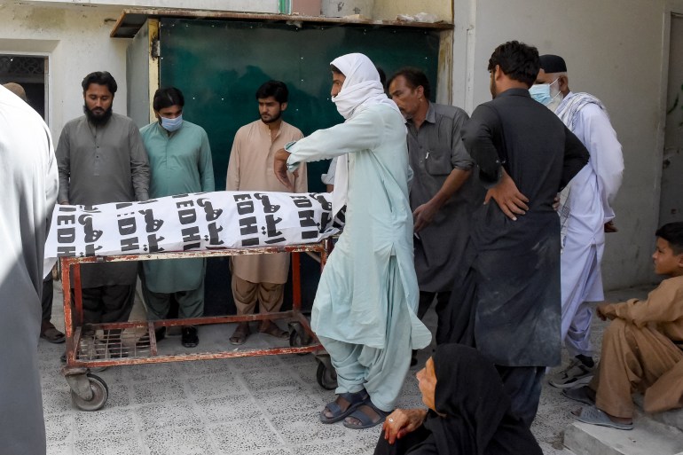 Relatives carry the body of a victim, who died in a separatist militants shooting, to a hospital in Quetta on August 26, 2024. - Separatist militants killed at least 39 people in "coordinated" attacks in southwestern Pakistan on August 26, that largely targeted ethnic Punjabis, government officials said. (Photo by Banaras KHAN / AFP)