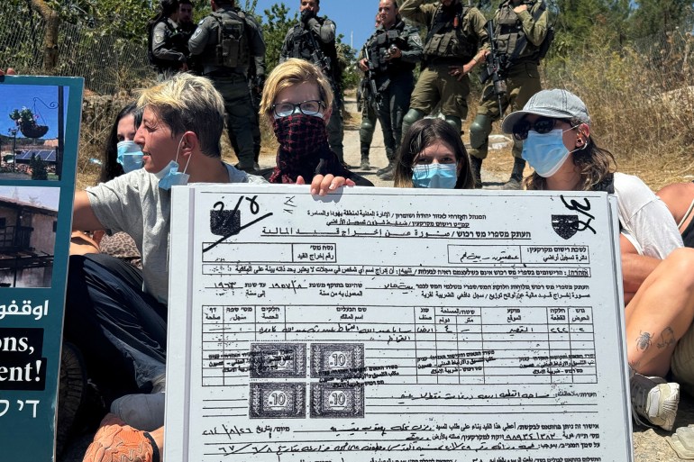 Activists display a banner during a protest against Israeli settlements, near Bethlehem, in the Israel-occupied West Bank August 8, 2024. REUTERS/Yosri Aljamal