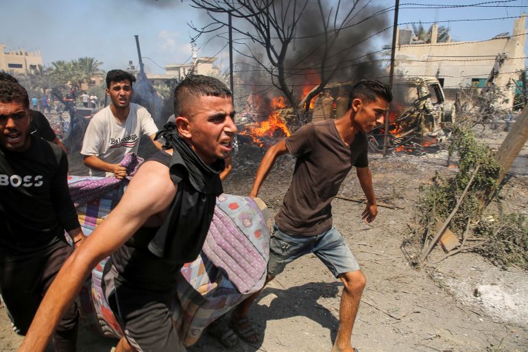 People carry a casualty at the site of what Palestinians say was an Israeli strike at a tent camp in Al-Mawasi area, amid Israel-Hamas conflict, in Khan Younis in the southern Gaza Strip July 13, 2024. REUTERS/Hatem Khaled