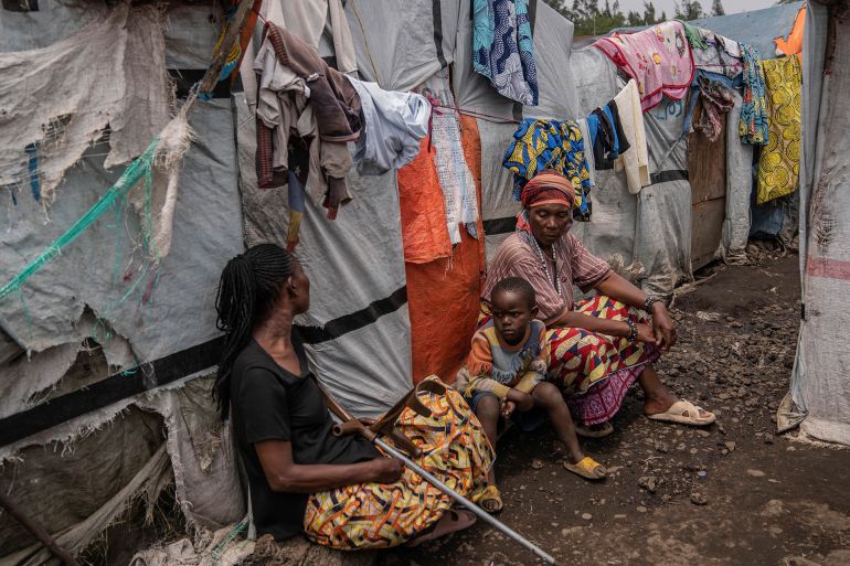 People sit at the Don Bosco refugee camp as Red Cross officials create awareness around mpox in Goma, Democratic Republic of Congo, Thursday, Aug. 22, 2023. (AP Photo/Moses Sawasawa)