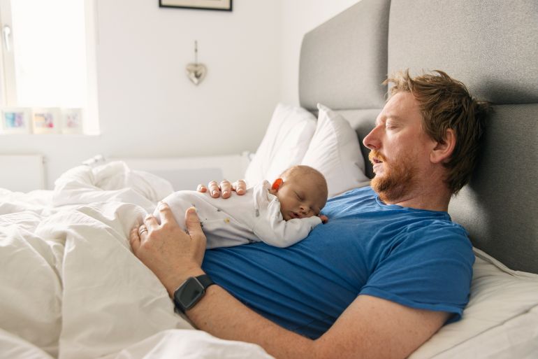 Newborn baby asleep on father's chest