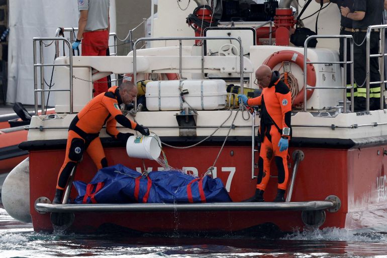 Rescue personnel pour water on a body bag containing the corpse of British entrepreneur Mike Lynch, who died when a yacht owned by his family sank off the coast of Porticello, near the Sicilian city of Palermo, Italy, August 22, 2024. REUTERS/Louiza Vradi TPX IMAGES OF THE DAY