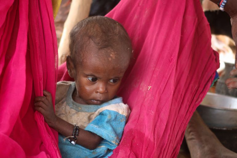 A child sits in their mother's lap in a makeshift shelter, following devastating floods, in Tokar, Red Sea State, Sudan, August 28, 2024. REUTERS/El Tayeb Siddig