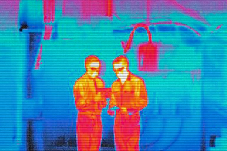 Infra red heat image of factory workers - stock photo