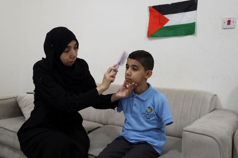 Mahmoud Ajjour, an injured child evacuated from Gaza, sits at home with his mother as she prepares him for school, in Doha, Qatar, September 10, 2024. REUTERS/Ibraheem Abu Mustafa