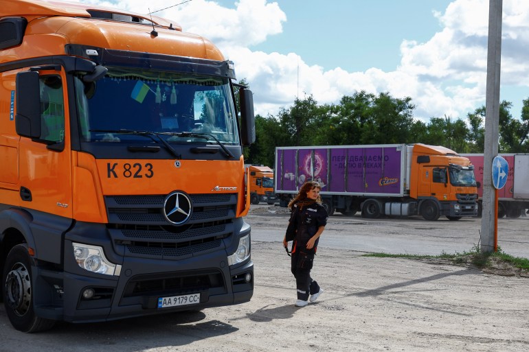 Driver Liliia Shulha walks to her truck at a compound of a logistics company, amid Russia's attack on Ukraine, in the village of Trebukhiv, Kyiv region, Ukraine August 13, 2024. REUTERS/Valentyn Ogirenko