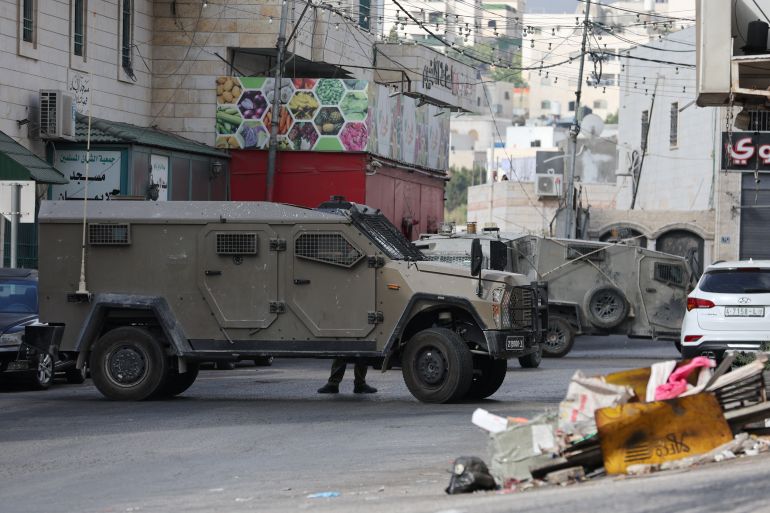 Armoured vehicles are seen as Israeli forces take position during a raid in Hebron, in the Israeli-occupied West Bank, August 31, 2024. REUTERS/Mussa Qawasma