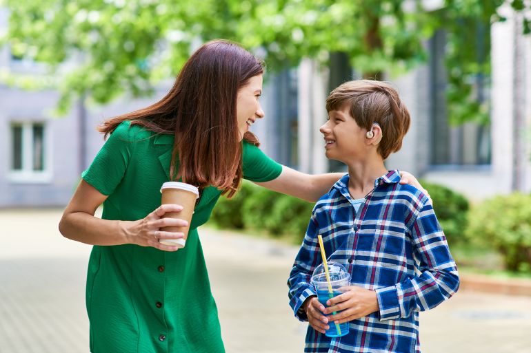 a mother shares a cheerful moment with her son, enjoying their drinks together. المصدر : إنفاتو