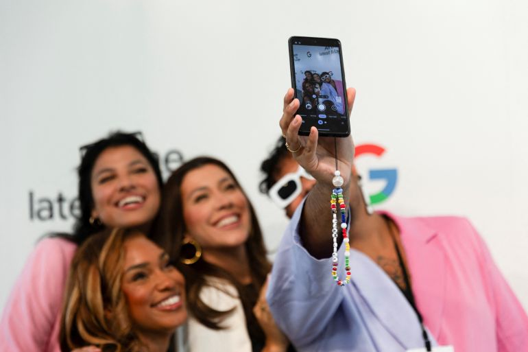 Team Pixel content creators take a selfie with the Pixel 8 smart phone at the Made by Google event in Mountain View, California, U.S. August 13, 2024. Google unveils a new line of Pixel smartphones, plus a new smart watch and wireless earbuds at its annual hardware event. REUTERS/Manuel Orbegozo