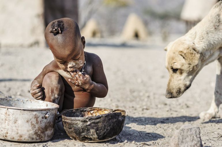 KUNENE, NAMIBIA - 2014/09/09: Himba child eating from a rusty pot. (Photo by Jorge Fernández/LightRocket via Getty Images)