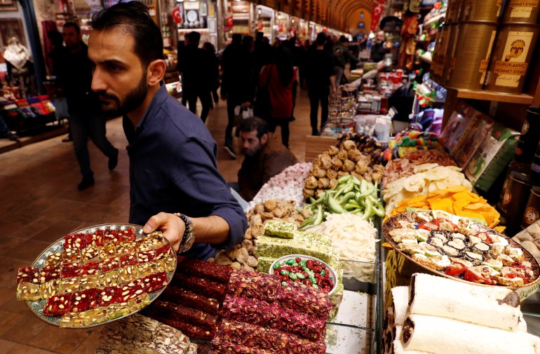 a vendor offers traditional turkish sweets to tourists at the spice market, also known as the egyptian bazaar, in istanbul, turkey january 25, 2019. reuters/murad sezer