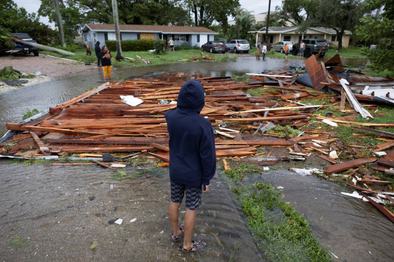 a man looks at a roof on a street from a nearby house after a tornado hit the area as hurricane milton approaches fort myers, florida, u.s. october 9, 2024. reuters/ricardo arduengo